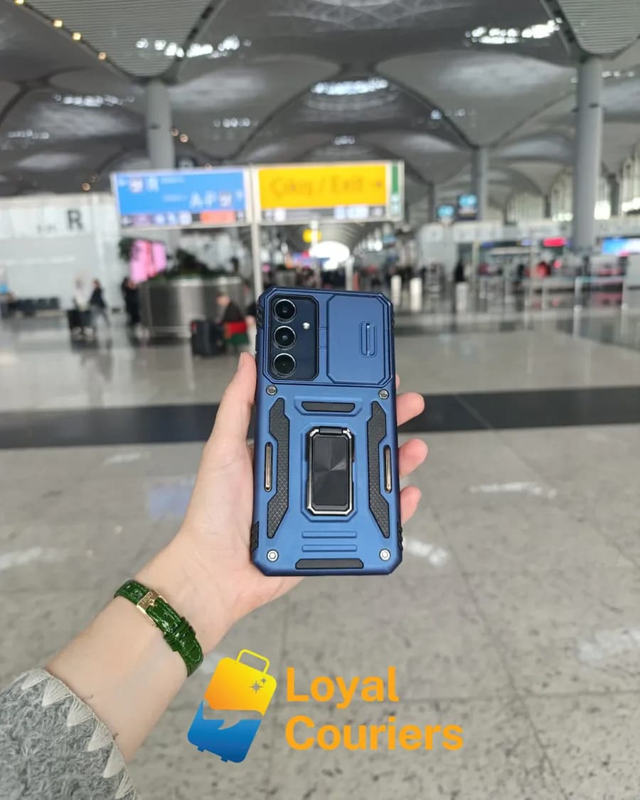 Terminalde elde tutulan mavi dayanıklı kılıflı bir telefon.