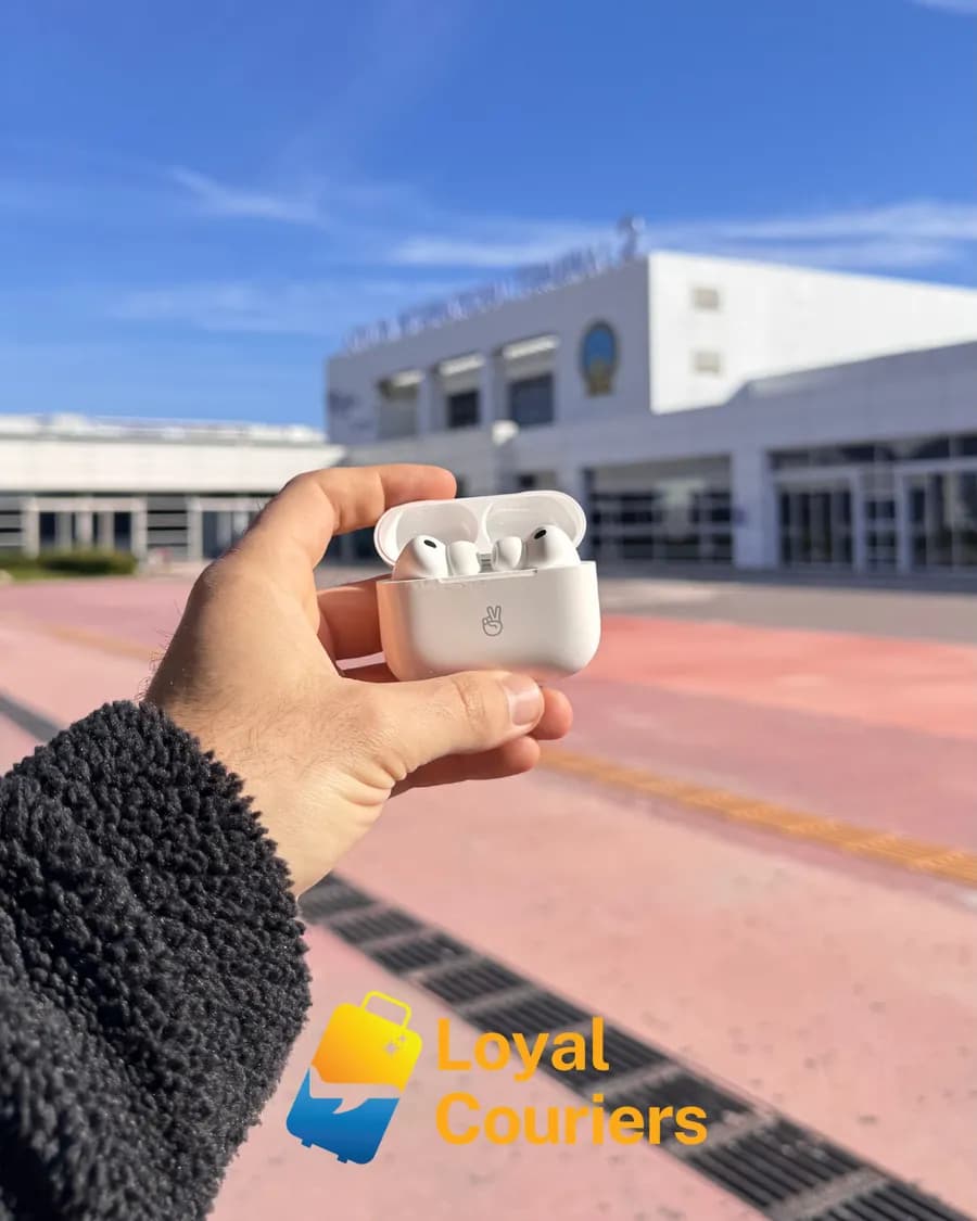 Terminal dışında güneşte elde tutulan, kutusunda bir çift kablosuz kulaklık.