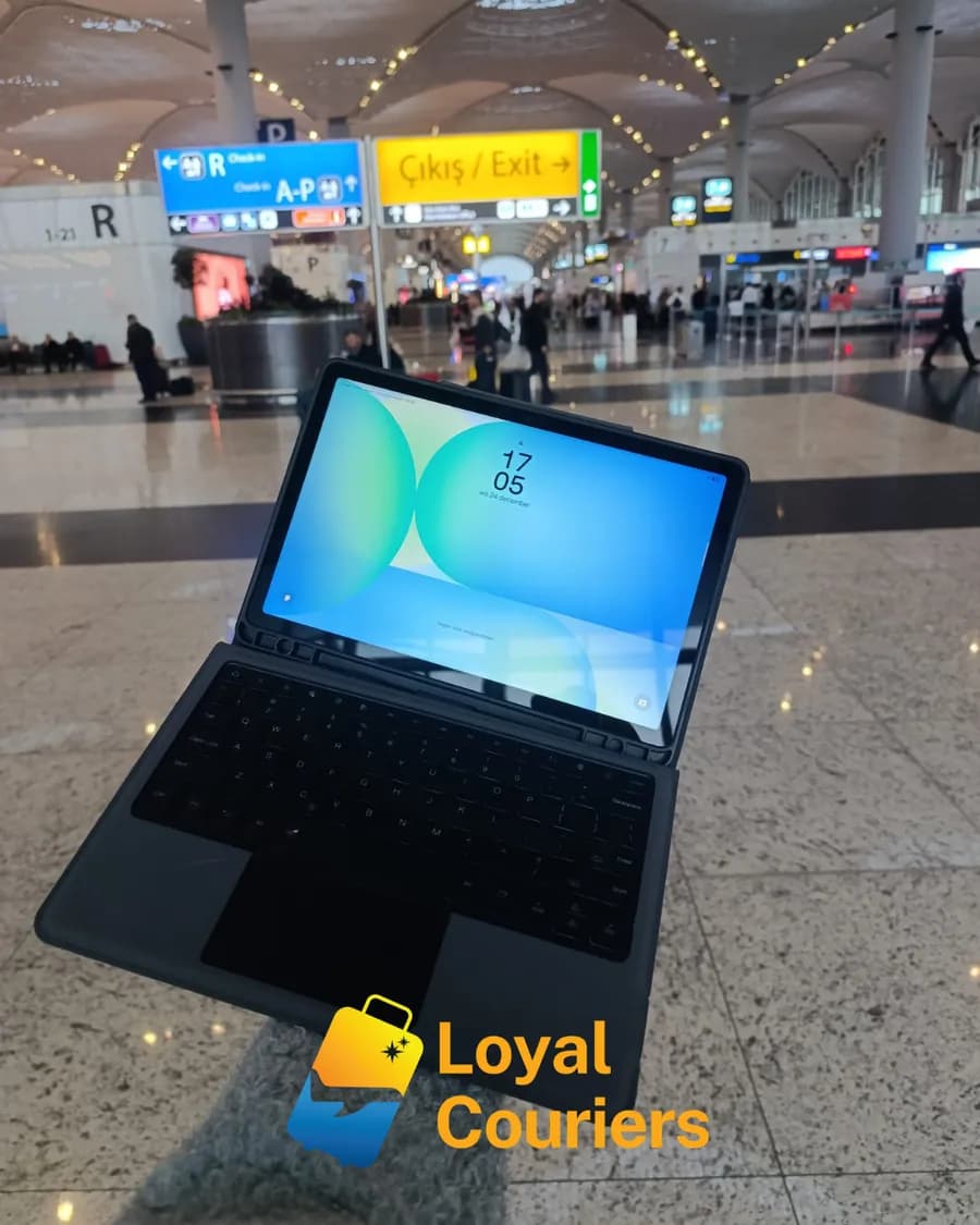 Gidiş salonunda elde tutulan klavyeli kılıflı bir tablet.
