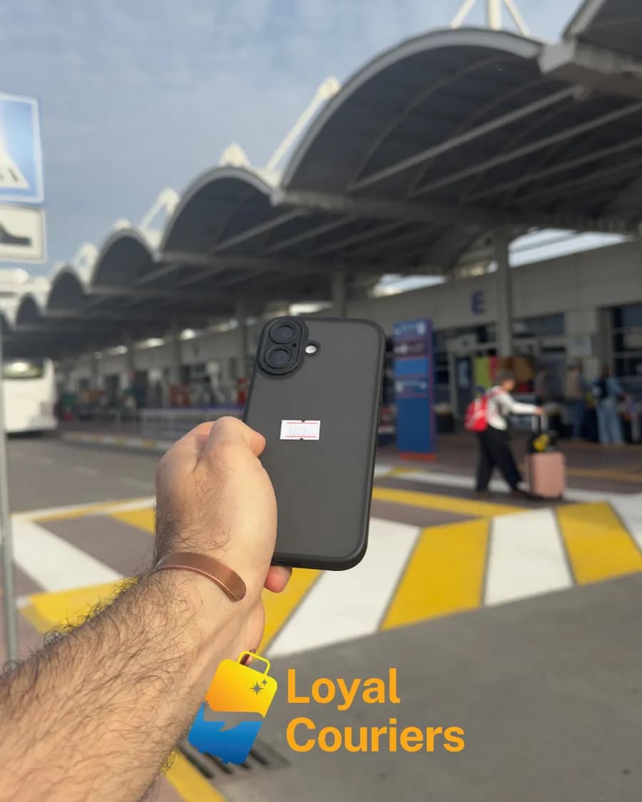 Terminal dışında elde tutulan, kayıp eşya etiketli siyah kılıflı bir telefon.